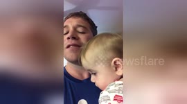 Father sings baby to sleep