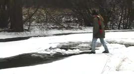 Funny man broke through ice into cold water on the river.