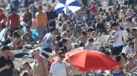 Long zoom of a busy Brighton beach on a summers day