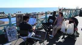 Brighton beach caricature artist sketches on hot day ( 1 of 3 )