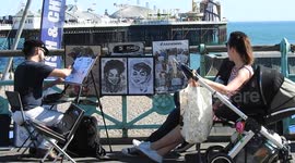 Brighton beach caricature artist sketches on hot day ( 2 of 3 )
