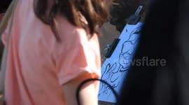 Brighton beach caricature artist sketches on hot day ( 3 of 3 )