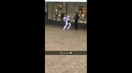 Man with walking stick dances along to street musician