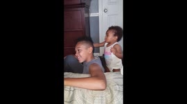 Baby sister brushing brothers fluffy hair