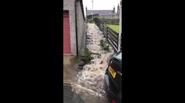 Floodwater gushes down steps after heavy rain in Scotland