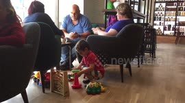 Child playing with toys in a cofffe shop