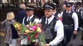 Police carry flowers past Borough Market