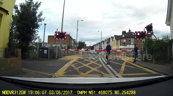 A Man Jumping Over Train Crossing Barriers