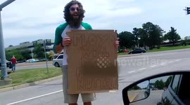 Conor Mcgregor fan stands beside road holding hilarious sign