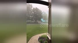 Bright blue electric arc travels on power line during hail storm
