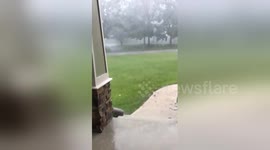 Bright blue electric arc travels on power line during hail storm