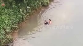 Delivery man jumps over five-metre riverbank to rescue elderly woman