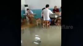 People remain in flooded house to play mahjong