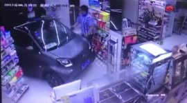 Man drives Smart Car into shop on rainy day