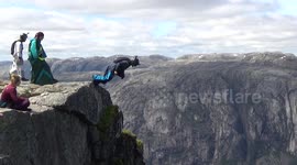 wingsuit Base jumpers exiting 3000ft high cliff at Heliboogie BASE jumping event in Norway