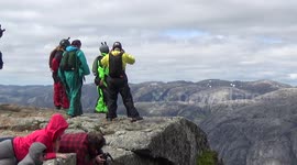 Base jumpers exiting 3000ft high cliff at Heliboogie BASE jumping event in Norway