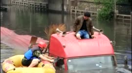 Firefighter uses dinghy to rescue lorry driver trapped on flooded road