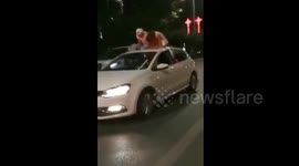 Man comforts woman on top of moving car after she broke up with her boyfriend