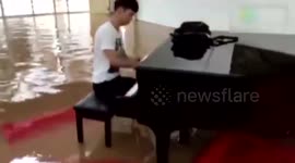University student plays piano in flooded hall