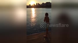 Newsflare Edit - Summer shot - kid jumping to the sea in sunset