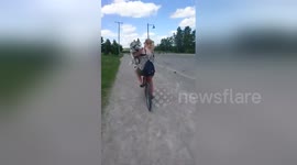 Husky hitches a ride on cyclist's back