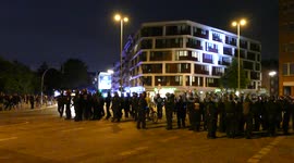 Group of riot officers standing in the street while convoy drives with sirens