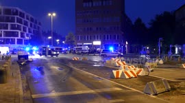 Extended shot of police vans driving through debris at night after protest