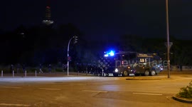 High tech police water cannon truck driving slowly with riot officers in Hamburg