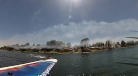 Airplane touching de lake with hte wing