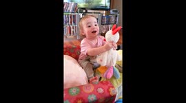 Daughter amused by a toy chicken
