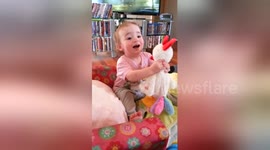 Newsflare Edit - Daughter amused by a toy chicken
