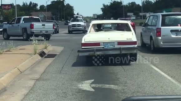 Guy drives a wrecked car with a bent frame