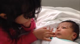 Sister meets her baby brother for the first time