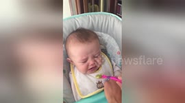 Baby pulls funny faces when trying avocado for the first time