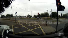 Motor bike wheelie in traffic at lights