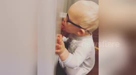 Baby practises his kissing skills on a fridge