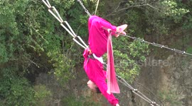 Father and daughter perform kung fu on tight rope over ravine