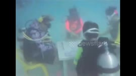 Chinese tourists play mahjong at bottom of sea