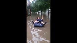 Russian man enjoys floods with lilo and a beer