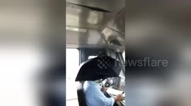 Leaking Indian train forces driver to sit beneath umbrella
