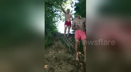 Newsflare Edit - Boy jumps into river on swing back somersault