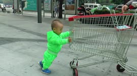Cute Chinese boy pushing a trolley