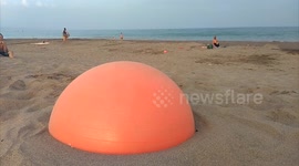 Acrobatic jumps at the beach with a pilates ball