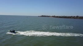 Jetski going across the water with land in background