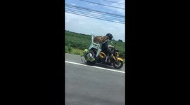 Motorcyclist cruises down busy road with two pet huskies