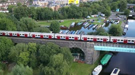 Watford London Metro Line Train crosses Bridge and Canal Aerial view 4K