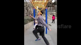 Elderly man moonwalking when hanging on monkey bars