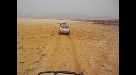 Ethiopia. Danakil Depression tour (15) Dallol -116m. Guíde hanging from car. 2016