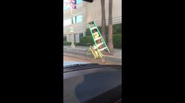Man cycling with a ladder