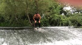 Man dives down water weir with trousers on